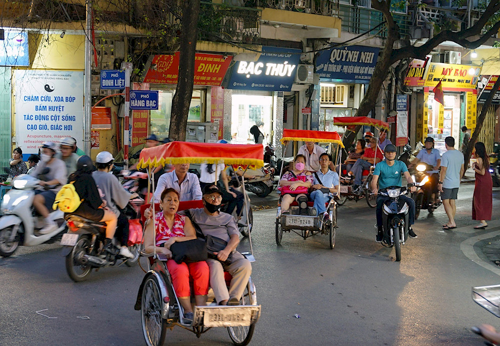Families visiting Vietnam enjoy taking a cyclo for its safety and easy access to daily Vietnamese culture along the streets